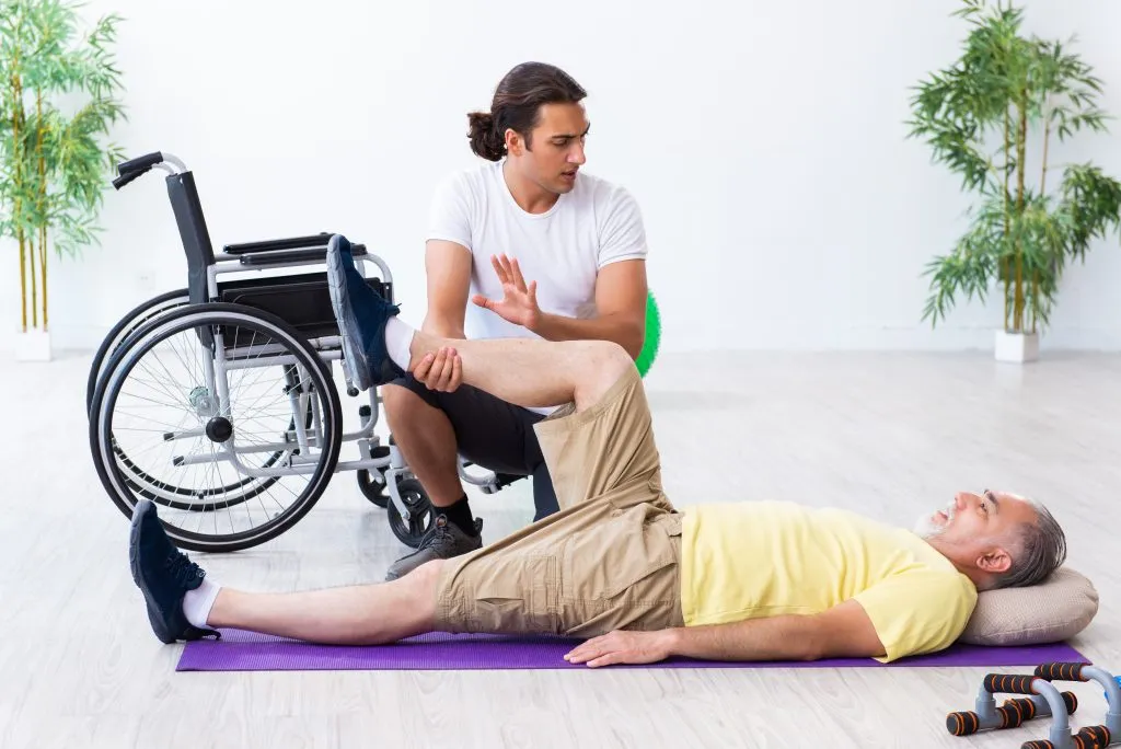 man undergoing physical therapy with trainer