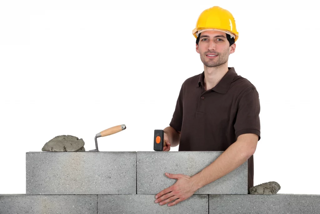 construction worker cementing hollow blocks