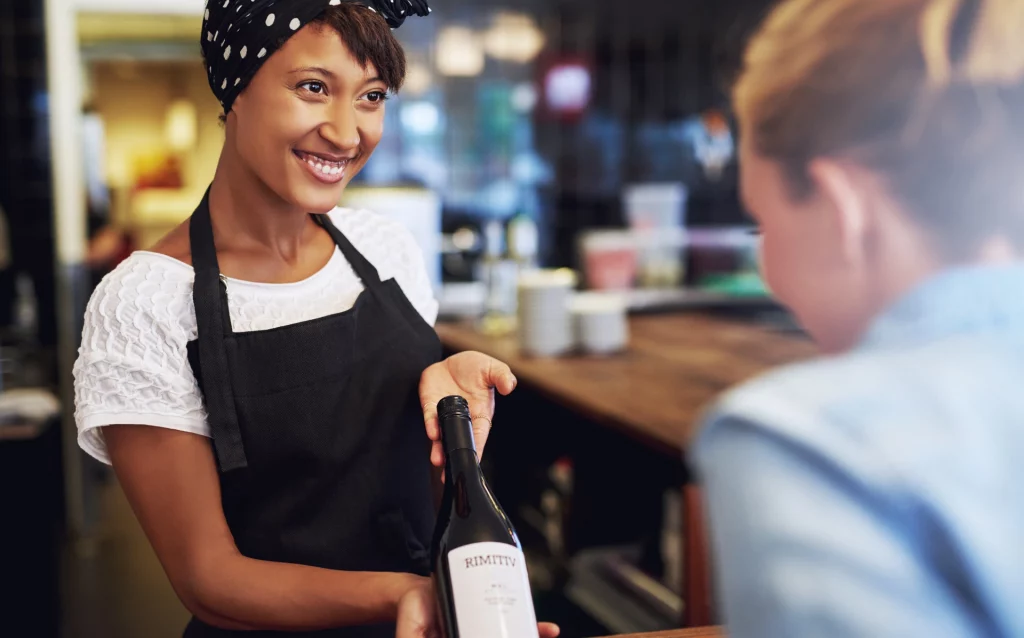 woman offering wine to a customer